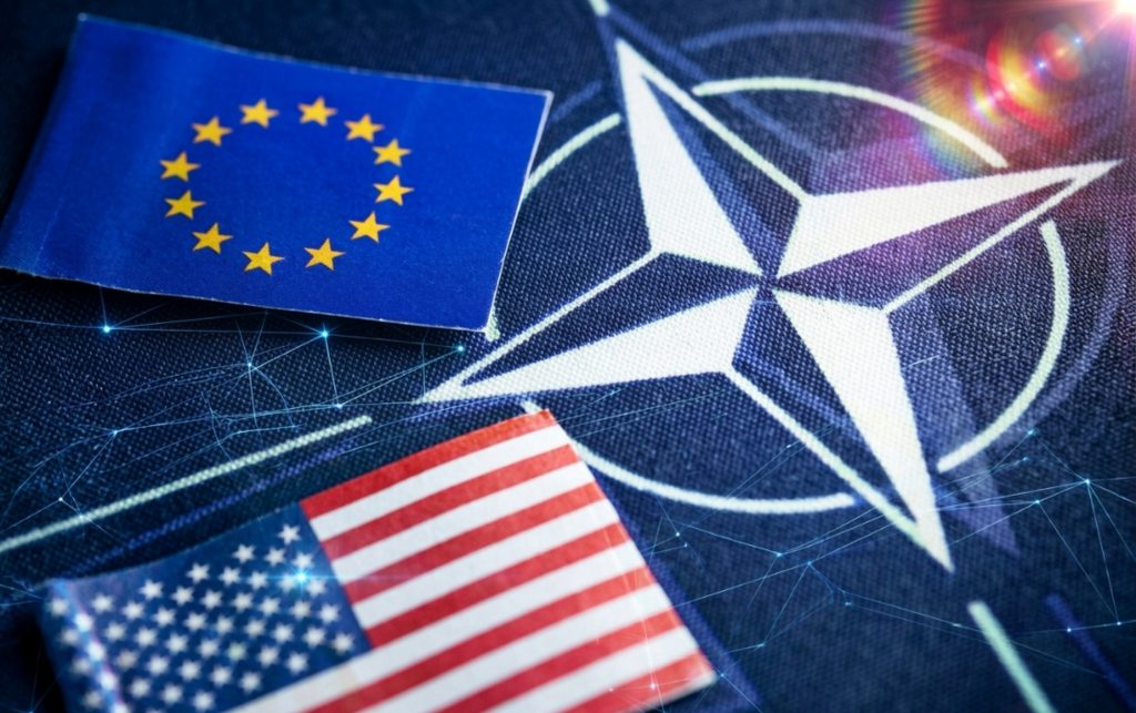 США не відмовилися від намірів скоротити підтримку НАТО: як Європа готується до змін Прапори НАТО, США та ЄС.
